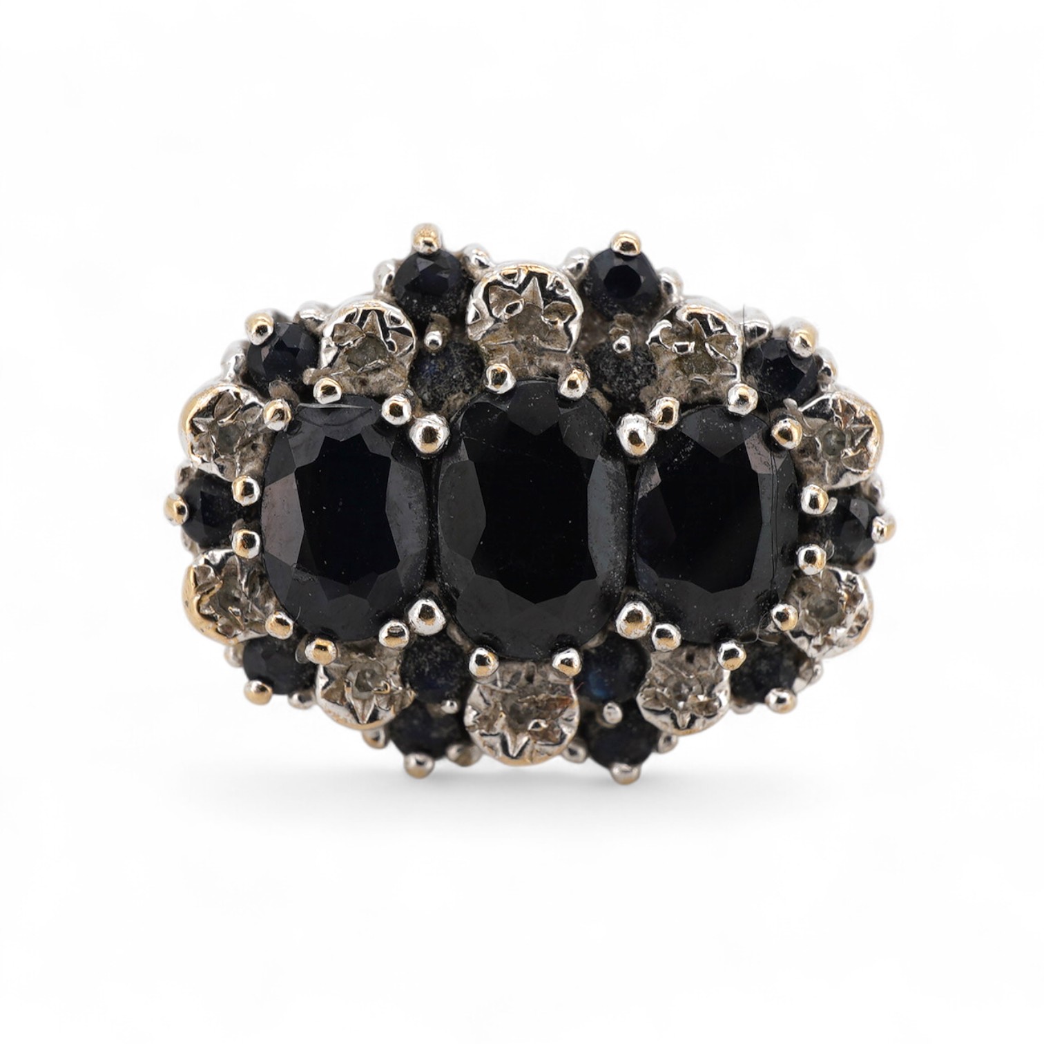 A modern 9ct gold and three stone sapphire set dress ring, with sapphire and diamond chip set border, size Q.